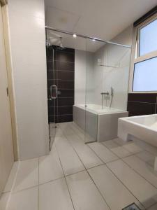een badkamer met een douche, een bad en een wastafel bij 2109 Encorp Marina Flex suite netflix By STAY in Nusajaya