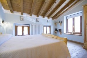 a large bedroom with a large bed with wooden ceilings at Casa delle Noci in Grimacco
