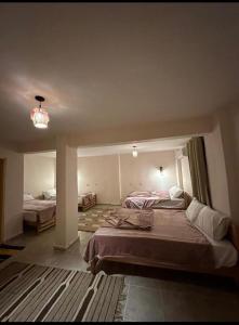 1 dormitorio con 2 camas y lámpara de araña en Elbadawy camp, en Nuweiba