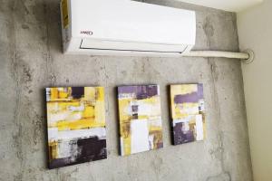trois œuvres d'art accrochées à un mur dans l'établissement 0509 iFreses Hermoso Apartamento con Aire Acondicionado y Parqueo, à Curridabat