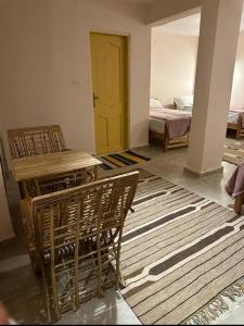 a room with a yellow door and a table and chairs at Elbadawy camp in Nuweiba