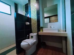 a bathroom with a white toilet and a sink at The S Design Hotel in Buriram
