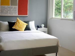 um quarto com uma cama com almofadas e uma janela em Emerald Manor Hotel em Kababae