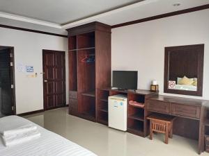 a bedroom with a bed and a desk with a television at Chongfah Mountain View in Khao Lak