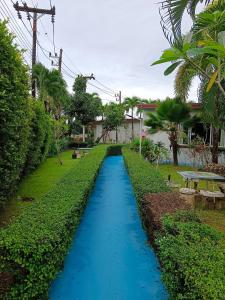 a blue pathway in front of a house with trees at Chongfah Mountain View in Khao Lak