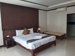 Schlafzimmer mit einem großen Bett mit einem Kopfteil aus Holz in der Unterkunft Chongfah Mountain View in Khao Lak