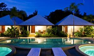 eine Villa mit einem Pool in der Nacht in der Unterkunft Chongfah Mountain View in Khao Lak