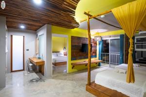 Zimmer mit einem Schlafzimmer mit einem Bett und einem TV in der Unterkunft Dugong Village-Green Hotel in Pak Meng