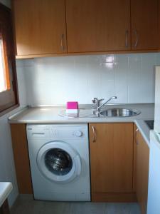 a kitchen with a washing machine and a sink at Casa Artio in Ansó