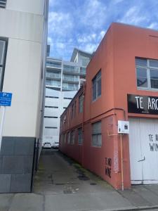 un edificio rojo con un cartel en el costado en Stylish 2 bedrooms townhouse in central Wellington, en Wellington