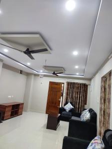 a living room with two couches and a ceiling fan at Rahuls castle in Visakhapatnam