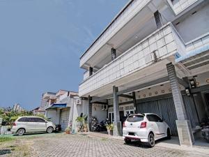 un coche blanco estacionado frente a un edificio en OYO 93072 Asri Homestay Syariah, en Parit