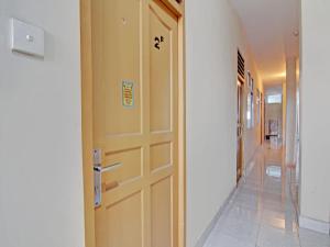 um corredor com uma porta de madeira e um corredor que leva a um quarto em OYO 93072 Asri Homestay Syariah em Parit