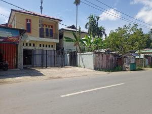 una calle vacía con una casa y una valla en OYO 93073 Penginapan 69 en Jayapura