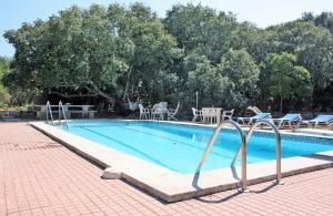 una piscina con sillas, mesa y árboles en Sa Cudia Cremada - Palacete en Mahón en Mahón