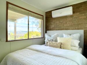 um quarto com uma cama grande e uma janela em The Beautiful Grand Terrace (Seaview) em Mount Martha