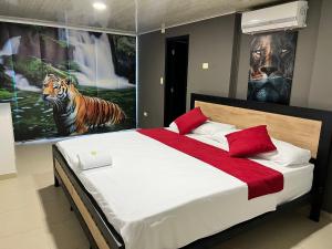 een slaapkamer met een bed met twee schilderijen aan de muur bij Hotel Entre Parques in La Dorada