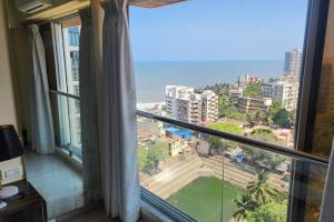 a room with a large window with a view of the ocean at Ocean View Luxury Designer condo in Mumbai