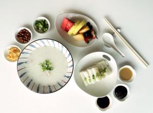 una mesa blanca con tazones de comida y palillos en The Olympian Hong Kong, en Hong Kong
