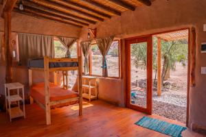 a bedroom with a bunk bed and a window at Cabaña Misk'i Nuna, en las afueras de Tilcara in Tilcara