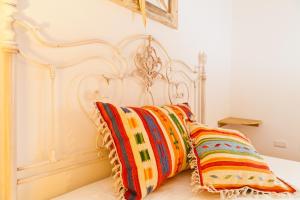 ムルタ・マリアにあるSmart Appart Cosy Sardiniaの白いベッド(カラフルな枕2つ付)