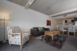 - un salon avec un canapé et une table dans l'établissement Dockside Apartments Kingston ACT, à Canberra
