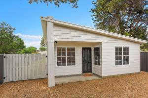 a white garage with a door and a fence at 24A Petrel Ave - Wi-Fi - No Linen Included in Encounter Bay