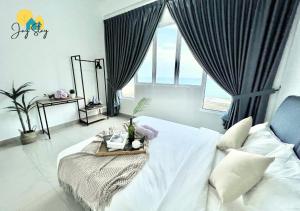 a bedroom with a bed with a tray on it at Amber Cove l Luxury Seaview 2BR l 6-8pax l GamesRoom l City Centre l Jonker St by Jay Stay in Melaka +85 photos