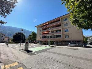 a building on a street in front of a building at Castelview - Sion next to the old town in Sion