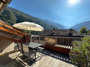 a table and chairs on a deck with a view at Le Nid - Versegere near Verbier - 4 Valleys in Versegeres 
