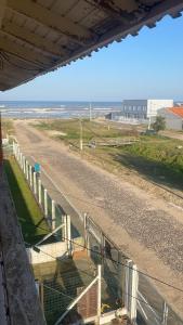 een uitzicht op een onverharde weg met een hek bij Apartamento Dúplex in Cidreira