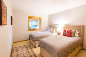 a bedroom with two beds and a window at #8107 Muirfield Crescent in Whistler