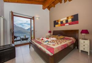 Pianello Del LarioにあるVilla Aquilaのベッドルーム1室(ベッド1台付)、景色を望むバルコニーが備わります。