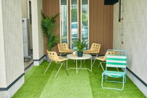 a balcony with a table and chairs on the grass at Orange County in Shinjuku in Tokyo