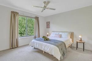 biała sypialnia z łóżkiem i oknem w obiekcie 'Hemmet House' A Smith Beach Locale with Ocean Views w mieście Rhyll