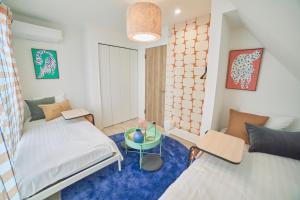 een slaapkamer met 2 bedden en een blauw tapijt bij Orange County in Shinjuku in Tokyo