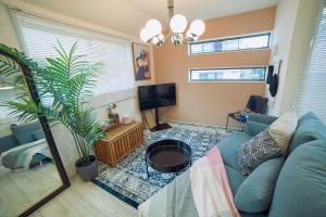 a living room with a blue couch and a tv at Orange County in Shinjuku in Tokyo