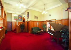 a living room with a piano and a red carpet at The County Hotel in Napier