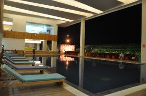 a hotel swimming pool with blue lounge chairs next to it at Hotel Grand Canyon in Raipur