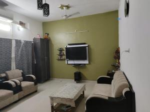 a living room with couches and a flat screen tv at Varanasi homestay in Varanasi