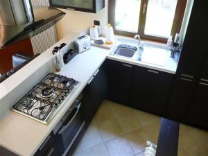 a kitchen with a stove top oven next to a sink at Clubhouse in Menaggio