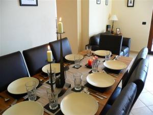 a dining room table with chairs and a long table with candles at Clubhouse in Menaggio