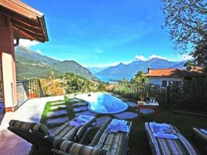 un patio trasero con piscina y vistas a las montañas en Clubhouse, en Menaggio