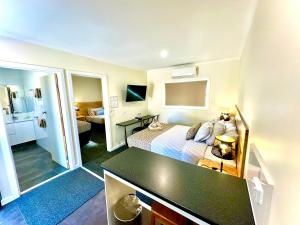 a small hotel room with a bed and a desk at Auto Lodge Motor Inn in Seymour