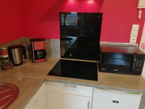 a kitchen with a black microwave and a counter at Nuit étoilée in Béthune +14 photos