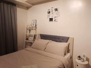 ein Bett in einem Schlafzimmer mit Bildern an der Wand in der Unterkunft Wind Residence T4- H Near Taal view & sky ranch in Nasugbu