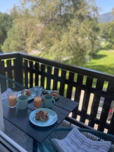 a table with cups and plates of food on it at Apartmán AkoDoma in Tatranská Lomnica +20 photos
