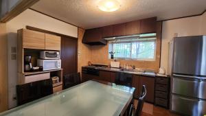 白馬的住宿－Hakuba Echoland Cottage，厨房配有木制橱柜和不锈钢冰箱。
