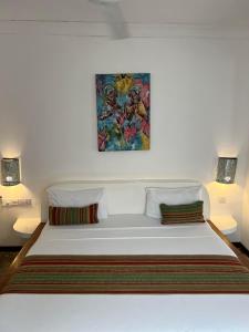 een bed in een kamer met een schilderij aan de muur bij Nungwi Getaway in Nungwi