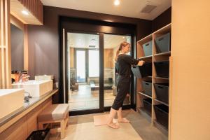 a woman is standing inside of a closet at HOTEL Cargo Shinsaibashi in Osaka